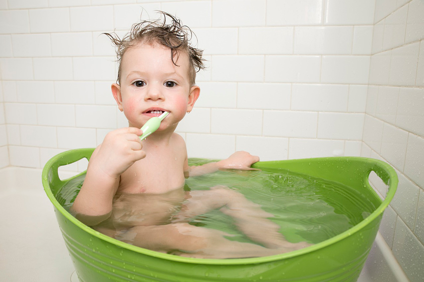 bebé en una tina lavándose