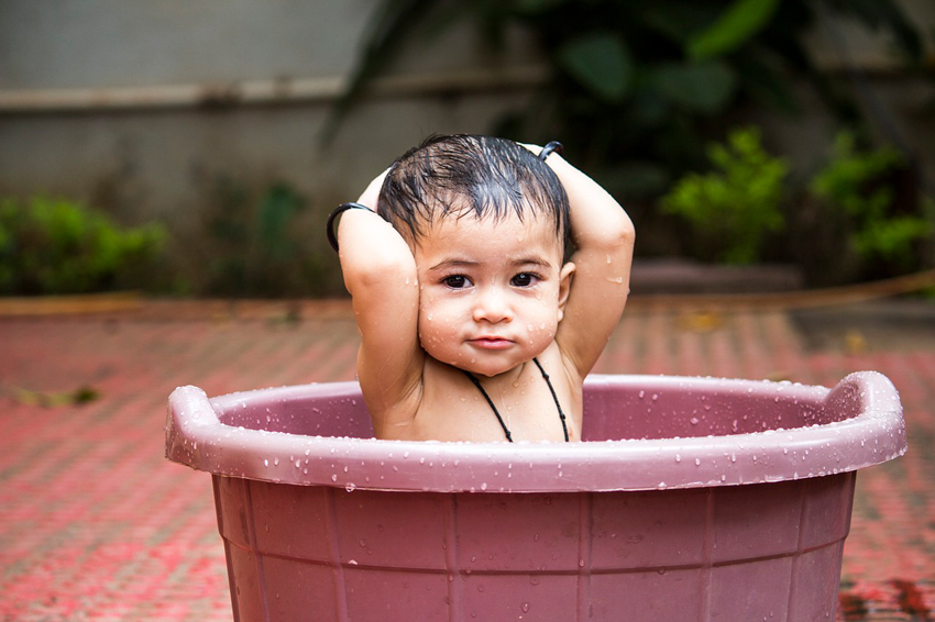 niño pequeño dentro de una tina dándose un baño